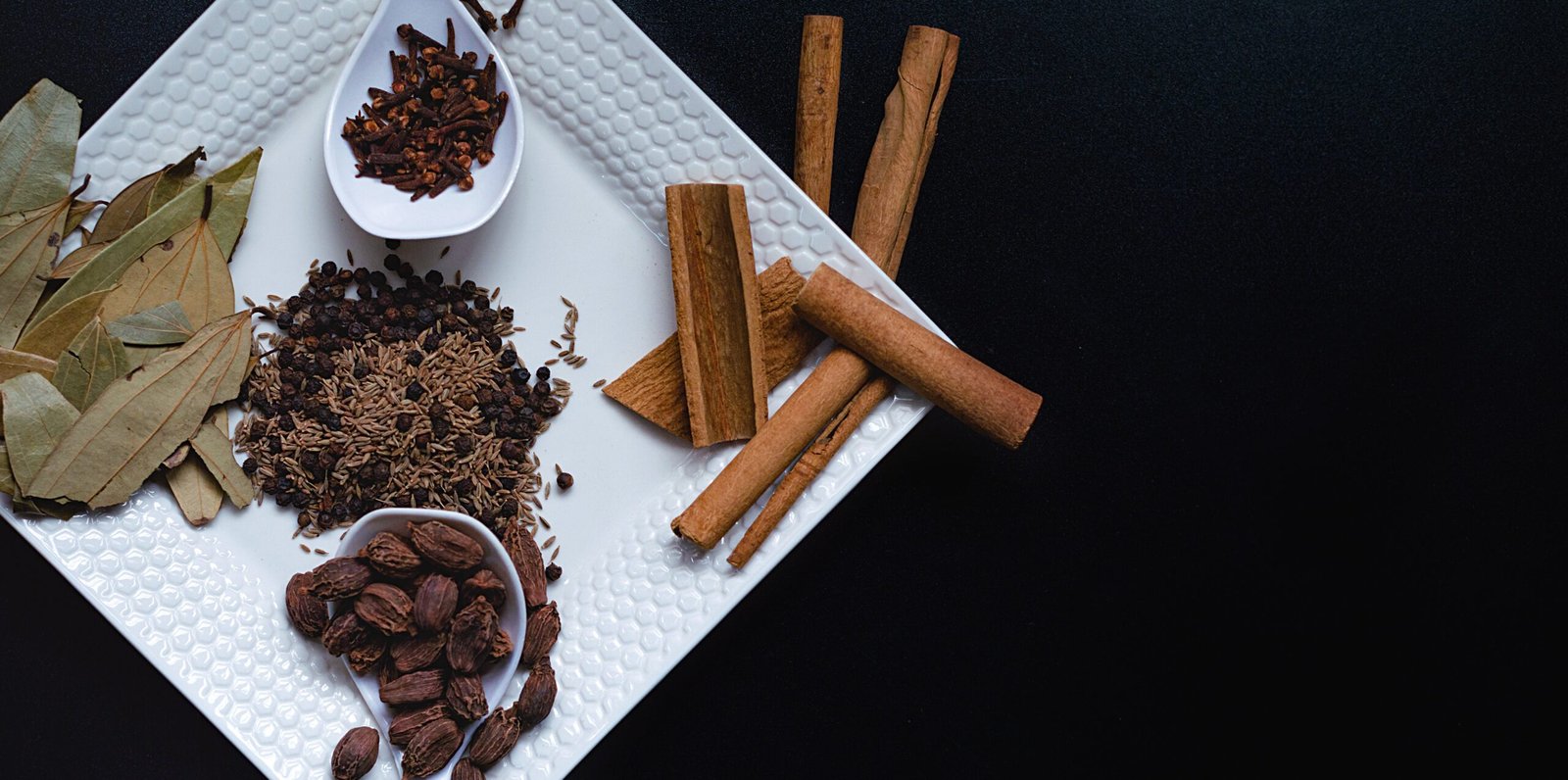 Pure and authentic Indian spices arranged in bowls on a wooden background
