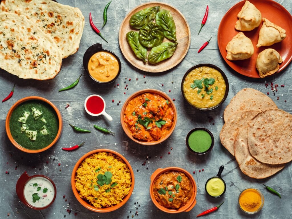 Indian snacks growing worldwide displayed through traditional Indian dishes in a flat lay.